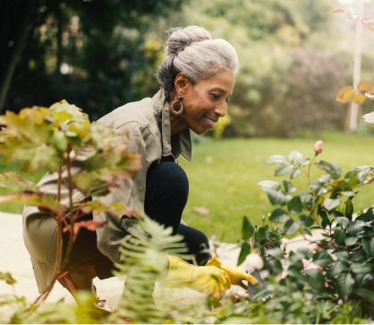 A 55+ years old woman kneeling down and gardening