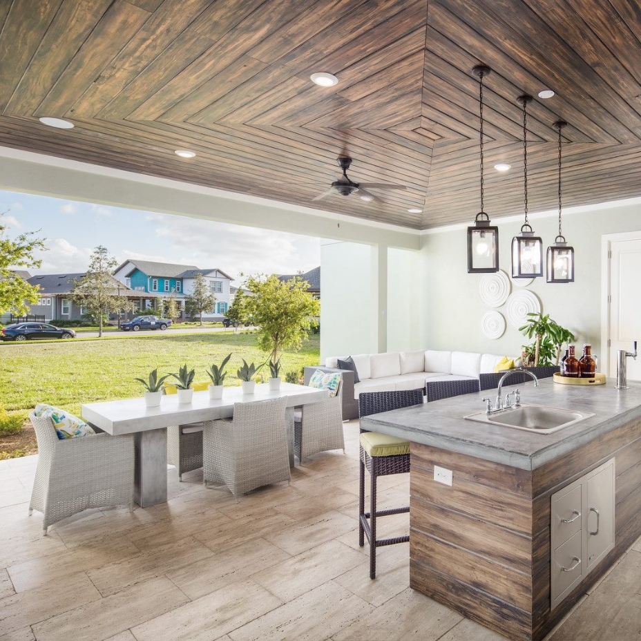 An outdoor kitchen with an island, table & chairs, and couch in Sunbridge community, St. Cloud, Florida in Metro Orlando