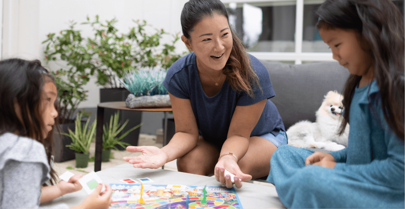 A mom playing a board game with her two daughters in Sunbridge community, St. Cloud, Florida in Metro Orlando