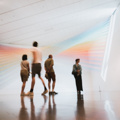 Group of four people walking around a museum looking at an art installation